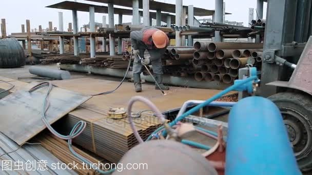 工業工人在防火均勻切割金屬薄板與丙烷氣體火炬燃燒器戶外